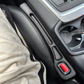 Renlori SeatGuard gap filler installed beside a car seat, with the seat belt buckle visible