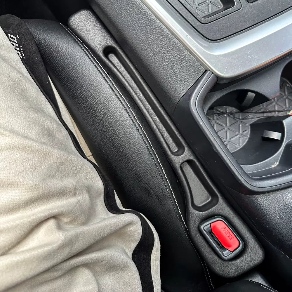 Renlori SeatGuard gap filler installed beside a car seat, with the seat belt buckle visible